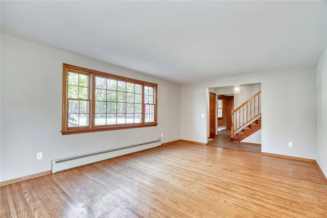 Formal living Room with Large Bay Window and hardwood flooring.