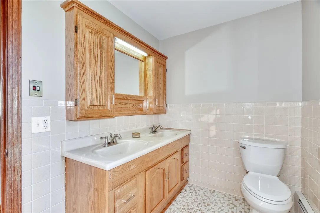 2nd floor MAIN bath is tiled and has a large double sink vanity and a newer tub/shower surround!