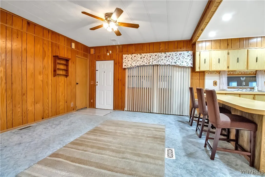 Carpeted living room overlooks Kitchen w/breakfast bar + 3 chairs