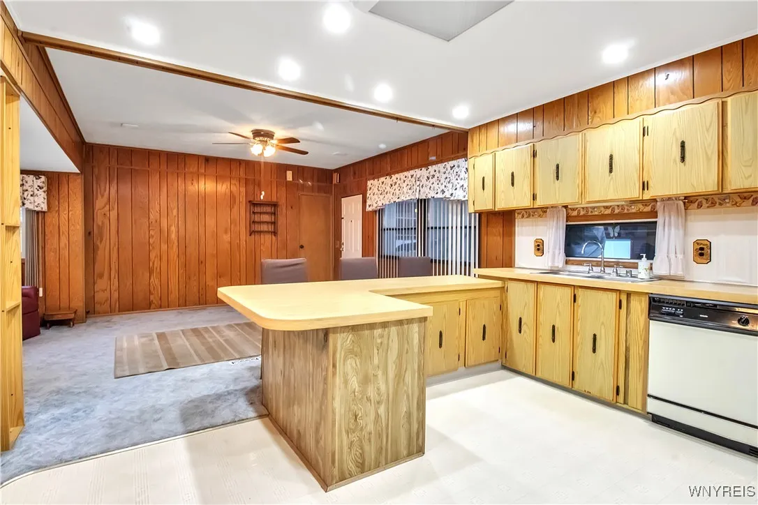 Kitchen overlooks carpeted + living room