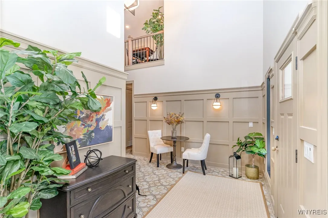 As you arrive, a spacious full front porch sets a warm and inviting first impression. Inside, a dramatic two-story foyer welcomes you and opens seamlessly into a bright, open-concept living space designed for both everyday comfort and effortless entertaining. Elegant custom wainscoting and thoughtfully selected designer lighting add architectural interest and a refined sense of sophistication, creating a stunning introduction to the home.