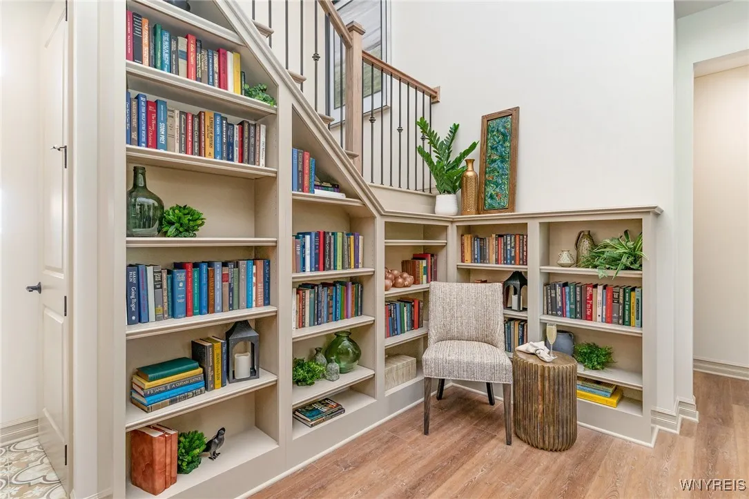The family room is a striking yet inviting space, enhanced by a soaring two-story ceiling that creates an open, light-filled atmosphere. A custom corner bookcase adds both architectural character and functional elegance, offering a beautifully designed focal point for display and storage. Together, these elements bring a sense of grandeur while maintaining a comfortable setting ideal for everyday living and entertaining.