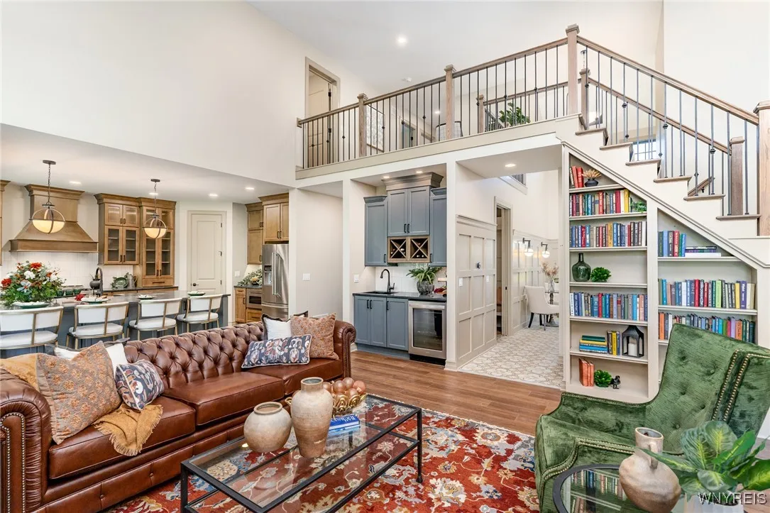 The family room is a striking yet inviting space, enhanced by a soaring two-story ceiling that creates an open, light-filled atmosphere. A custom corner bookcase adds both architectural character and functional elegance, offering a beautifully designed focal point for display and storage. Together, these elements bring a sense of grandeur while maintaining a comfortable setting ideal for everyday living and entertaining.