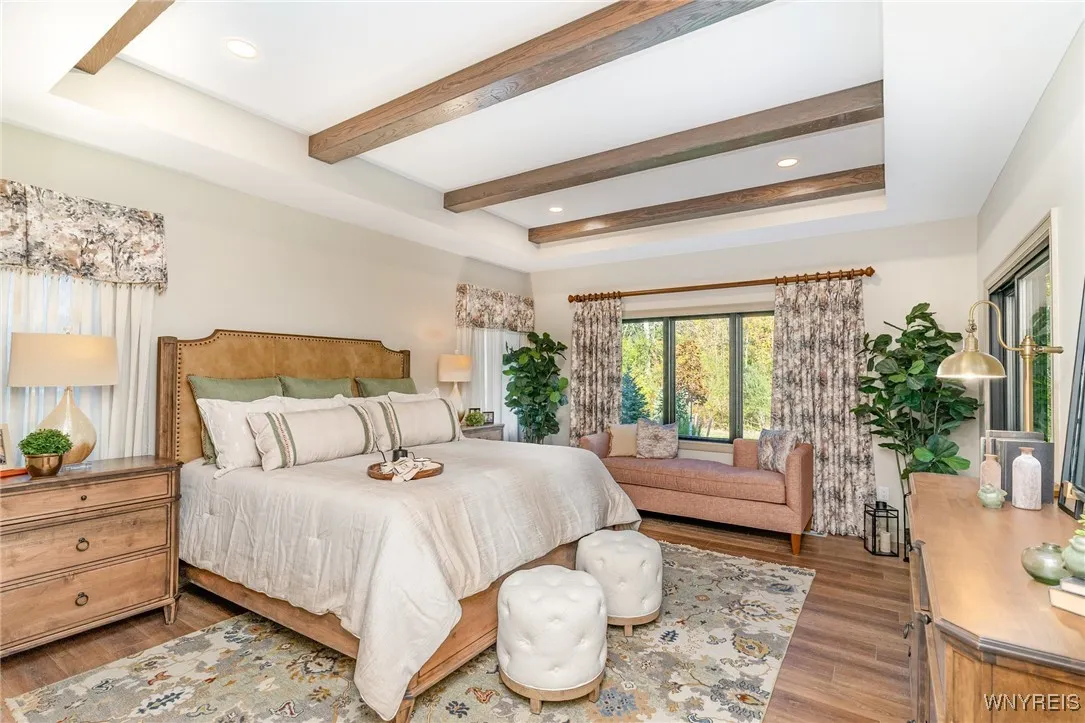The luxurious first-floor primary suite offers a true spa-inspired retreat with two walk-in closets. The primary bath features heated floors, double sinks, a ceramic tile shower, soaking tub, private commode room, and a spacious linen closet, along with sliding doors that lead directly to the covered rear porch.