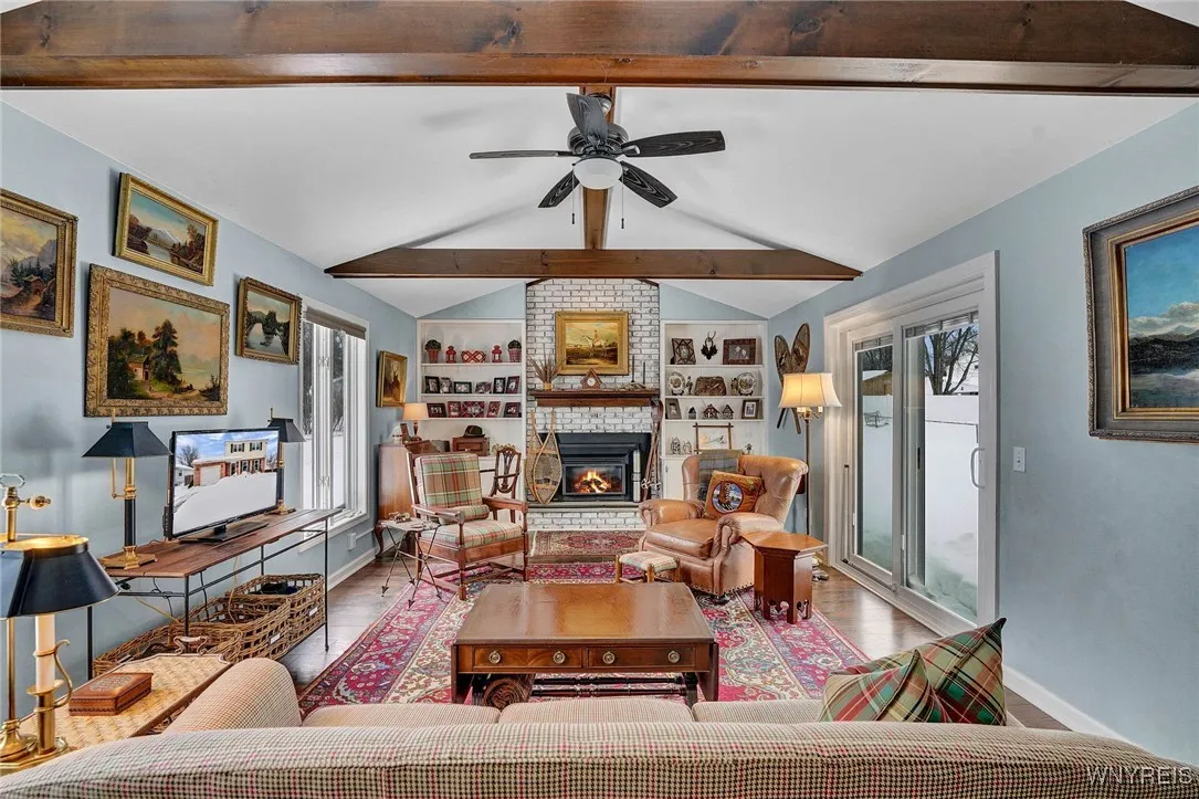 BRICK FIREPLACE WITH GAS INSERT FLANKED BY BOOKCASES