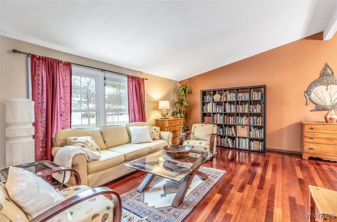 The living room offers an abundance of natural light through the newer front windows, The cathedral ceilings add to the feeling of spaciousness in this pretty room.