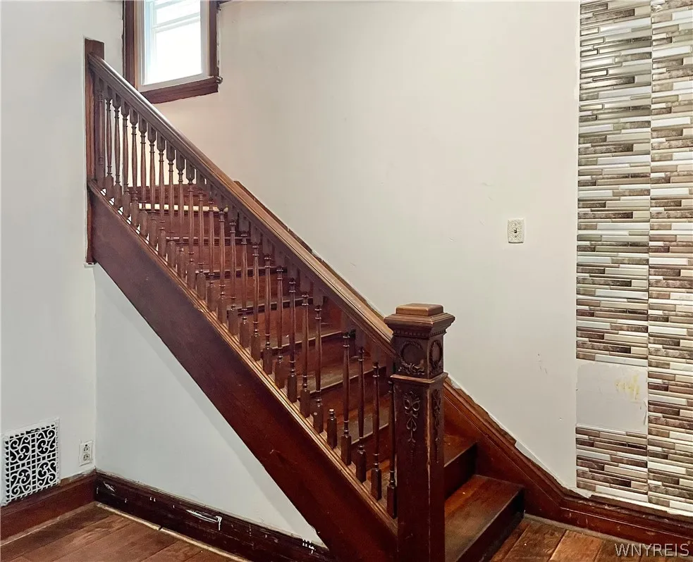 Tile looking wall section is not real tile but imitation tile - plastic stick down. Seems easily removable.