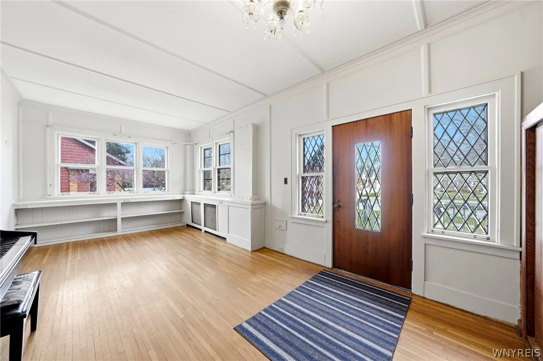 An etched glass front door and a four season room with hardwood floors, creates a wonderful first impression