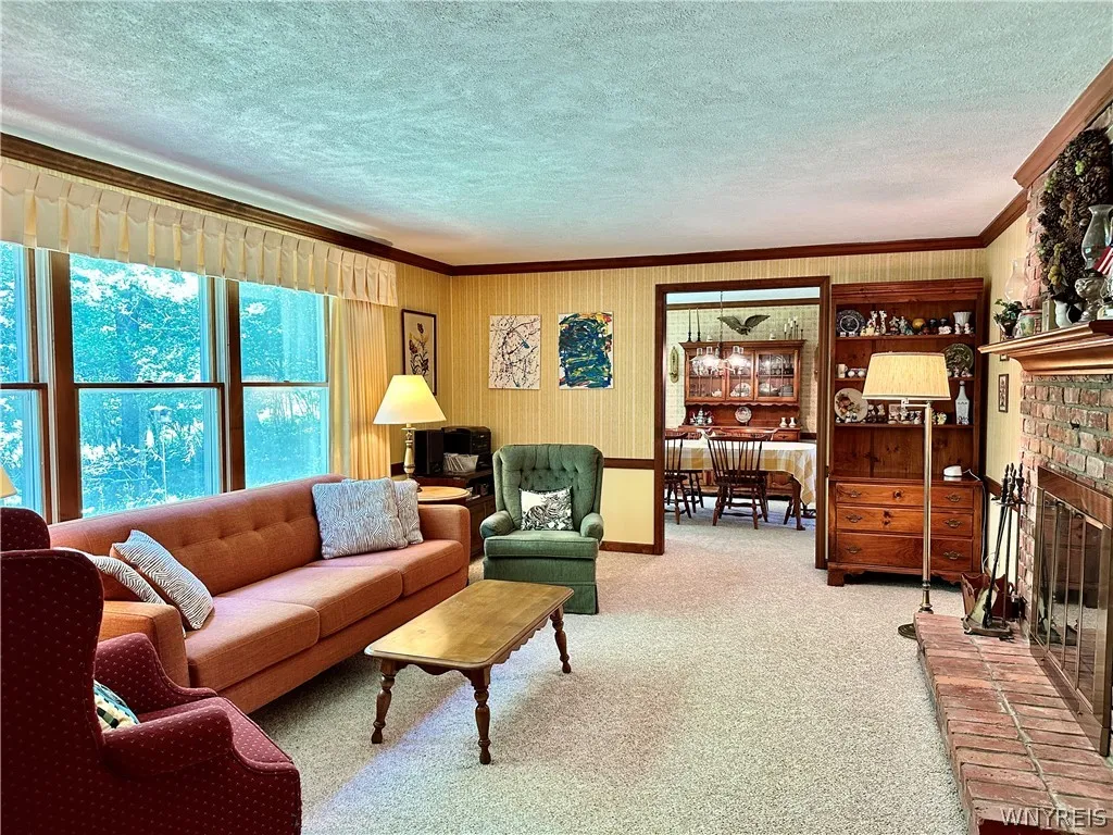 The spacious living room has windows looking out onto the private wooded backyard.