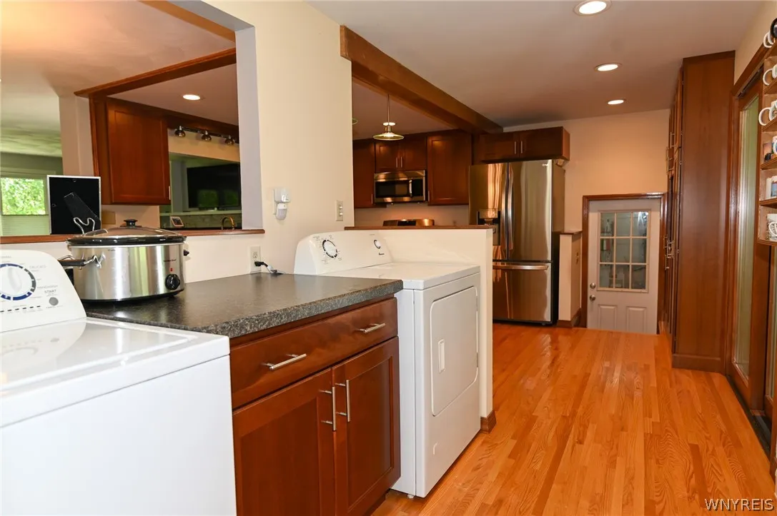 Washer, dryer next to kitchen. Door at end leads to basement and garage