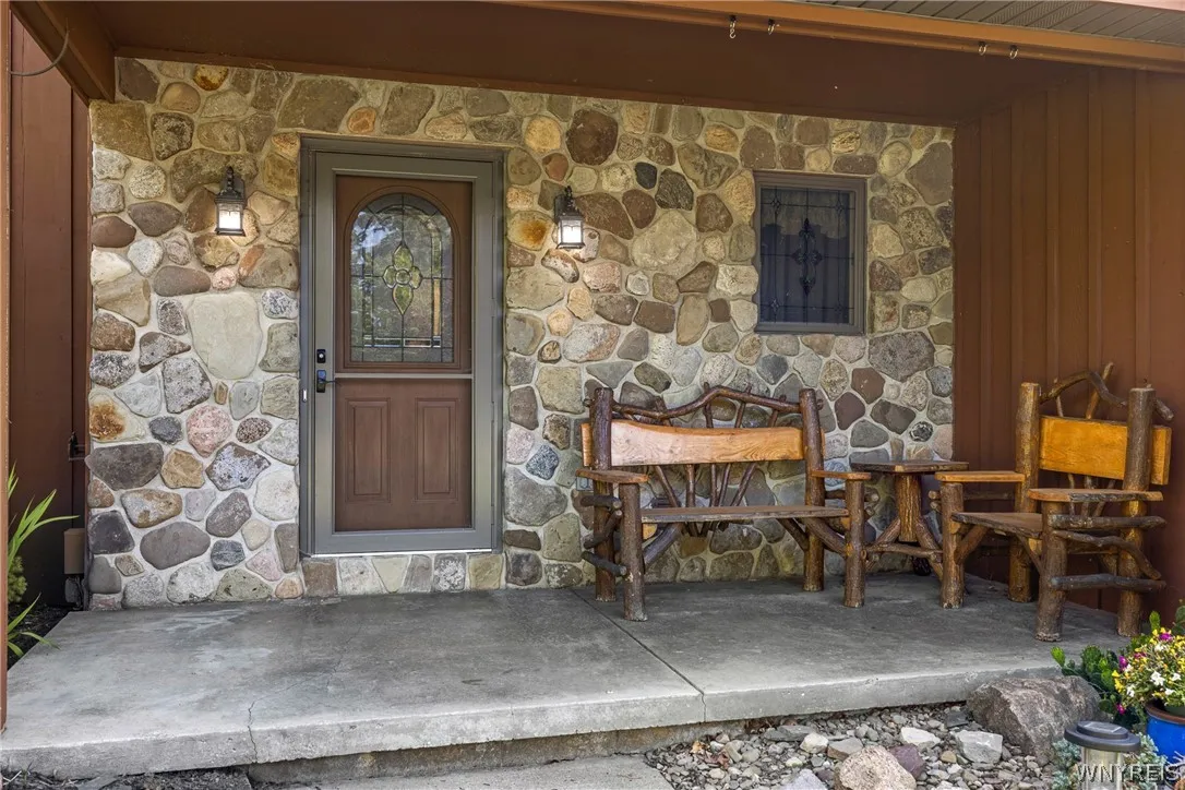 stone siding on front porch, log chair set incl