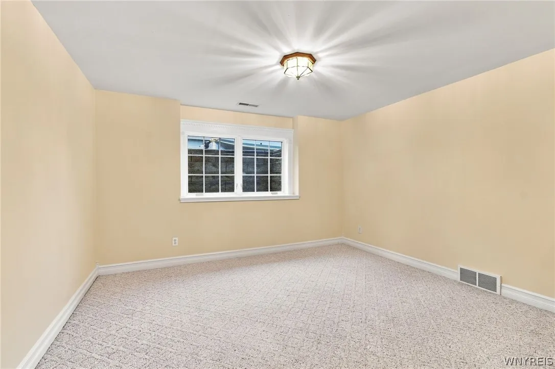 Basement/lower level  recreation space is fully carpeted and has egress window