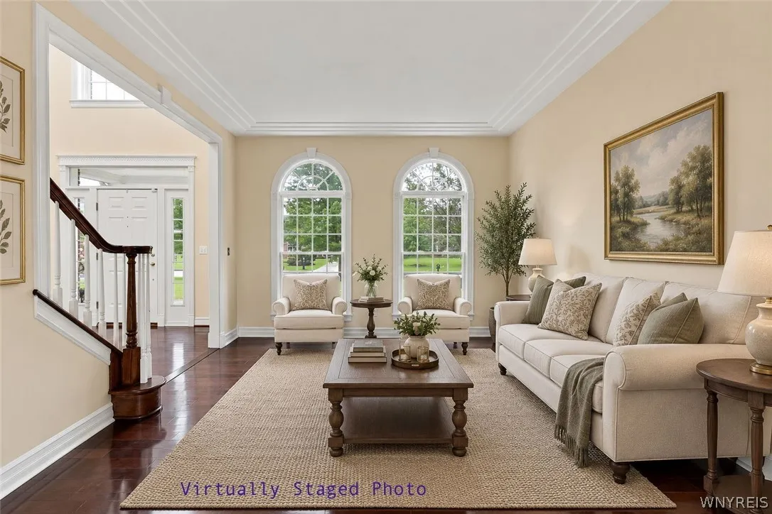 Perfect for entertaining, the elegant living & dining rooms flow seamlessly together in a beautiful,open-concept design.Just off the front foyer, the formal living room welcomes guests w/ stunning Rosewood floors,rich crown molding,& expansive windows framing serene outdoor views.Transitioning effortlessly into the formal dining rm, featuring timeless architectural details including classic wainscoting & an ornate brass chandelier.