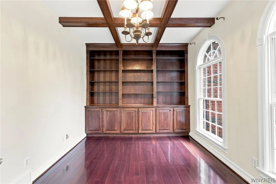 Glistening Rosewood floors flow from the foyer into a sophisticated den/office behind elegant double French doors, complete with an old-world coffered ceiling and custom built-in bookcases.

