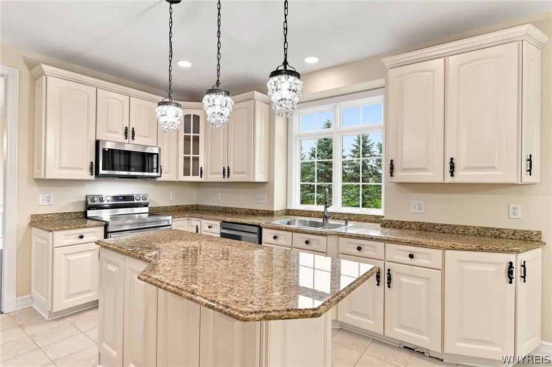 Spectacular kitchen is a chef’s dream, seamlessly blending modern updates w/ traditional elegance.Featuring all brand-new stainless-steel appliances, including a freestanding electric range oven,built-in microwave, refrig, & dishwasher. Gorgeous white cabinets with charming traditional hardware offer abundant storage,perfectly paired w/expansive granite countertops,integrated plate rack,& convenient walk-in pantry. Central island serves as a perfect prep station, illuminated by elegant pendant island lights