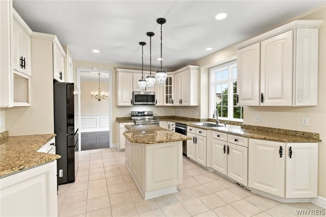 Spectacular kitchen is a chef’s dream, seamlessly blending modern updates w/ traditional elegance.Featuring all brand-new stainless-steel appliances, including a freestanding electric range oven,built-in microwave, refrig, & dishwasher. Gorgeous white cabinets with charming traditional hardware offer abundant storage,perfectly paired w/expansive granite countertops,integrated plate rack,& convenient walk-in pantry. Central island serves as a perfect prep station, illuminated by elegant pendant island lights