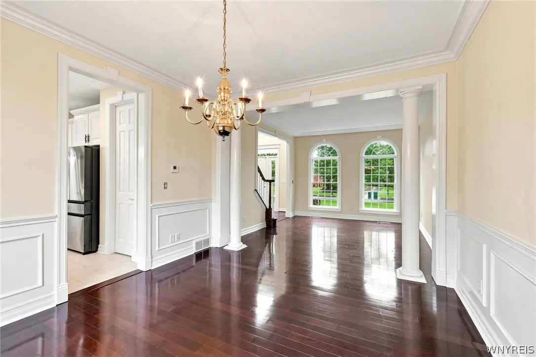 Perfect for entertaining, the elegant living & dining rooms flow seamlessly together in a beautiful,open-concept design.Just off the front foyer, the formal living room welcomes guests w/ stunning Rosewood floors,rich crown molding,& expansive windows framing serene outdoor views.Transitioning effortlessly into the formal dining rm, featuring timeless architectural details including classic wainscoting & an ornate brass chandelier.
