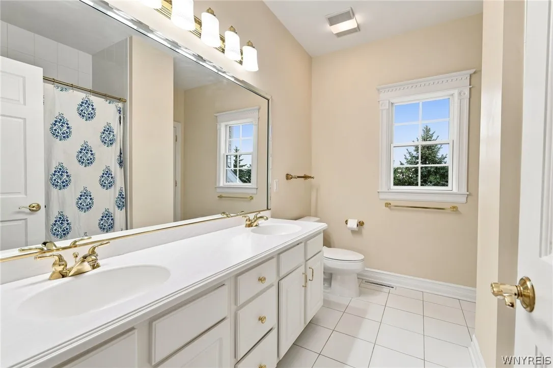 Main 2nd floor bathroom with double vanity, ceramic tile floors and tiled bath surround