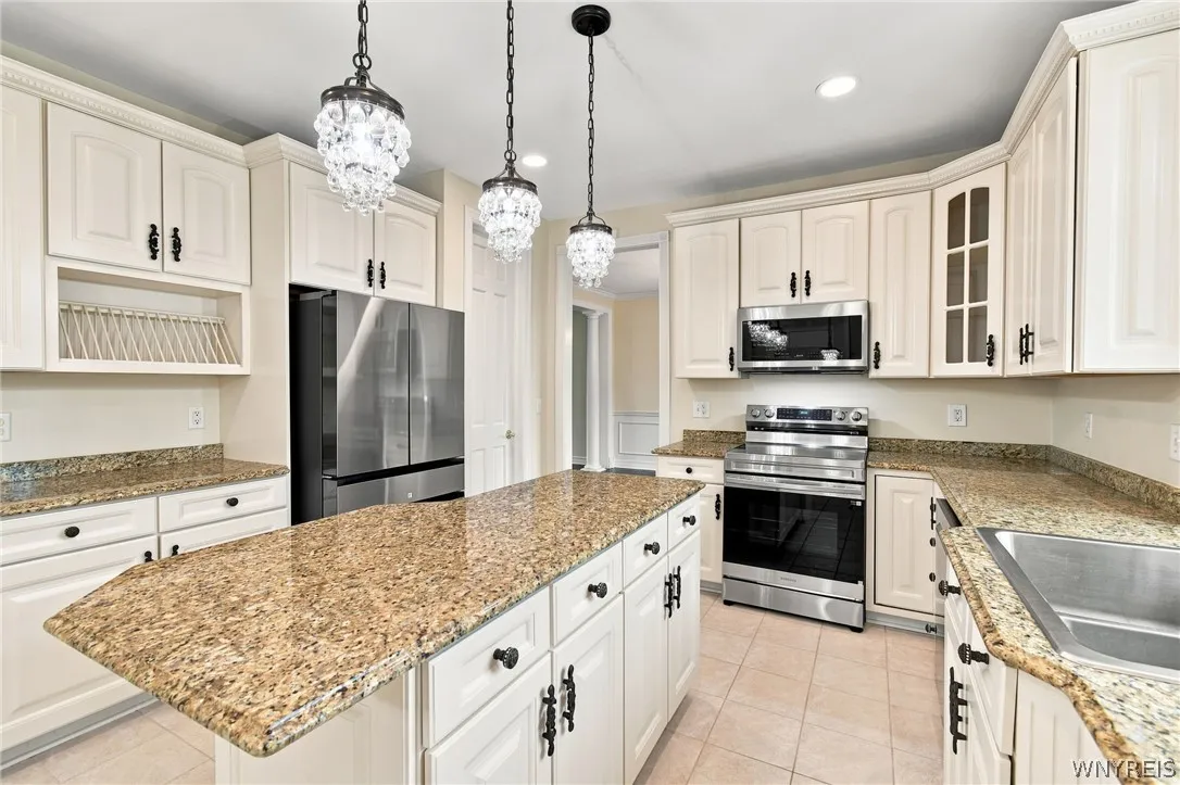 Spectacular kitchen is a chef’s dream, seamlessly blending modern updates w/ traditional elegance.Featuring all brand-new stainless-steel appliances, including a freestanding electric range oven,built-in microwave, refrig, & dishwasher. Gorgeous white cabinets with charming traditional hardware offer abundant storage,perfectly paired w/expansive granite countertops,integrated plate rack,& convenient walk-in pantry. Central island serves as a perfect prep station, illuminated by elegant pendant island lights