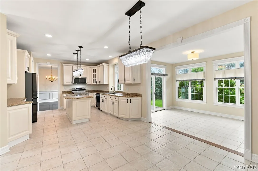 Spectacular kitchen is a chef’s dream, seamlessly blending modern updates w/ traditional elegance.Featuring all brand-new stainless-steel appliances, including a freestanding electric range oven,built-in microwave, refrig, & dishwasher. Gorgeous white cabinets with charming traditional hardware offer abundant storage,perfectly paired w/expansive granite countertops,integrated plate rack,& convenient walk-in pantry. Central island serves as a perfect prep station, illuminated by elegant pendant island lights