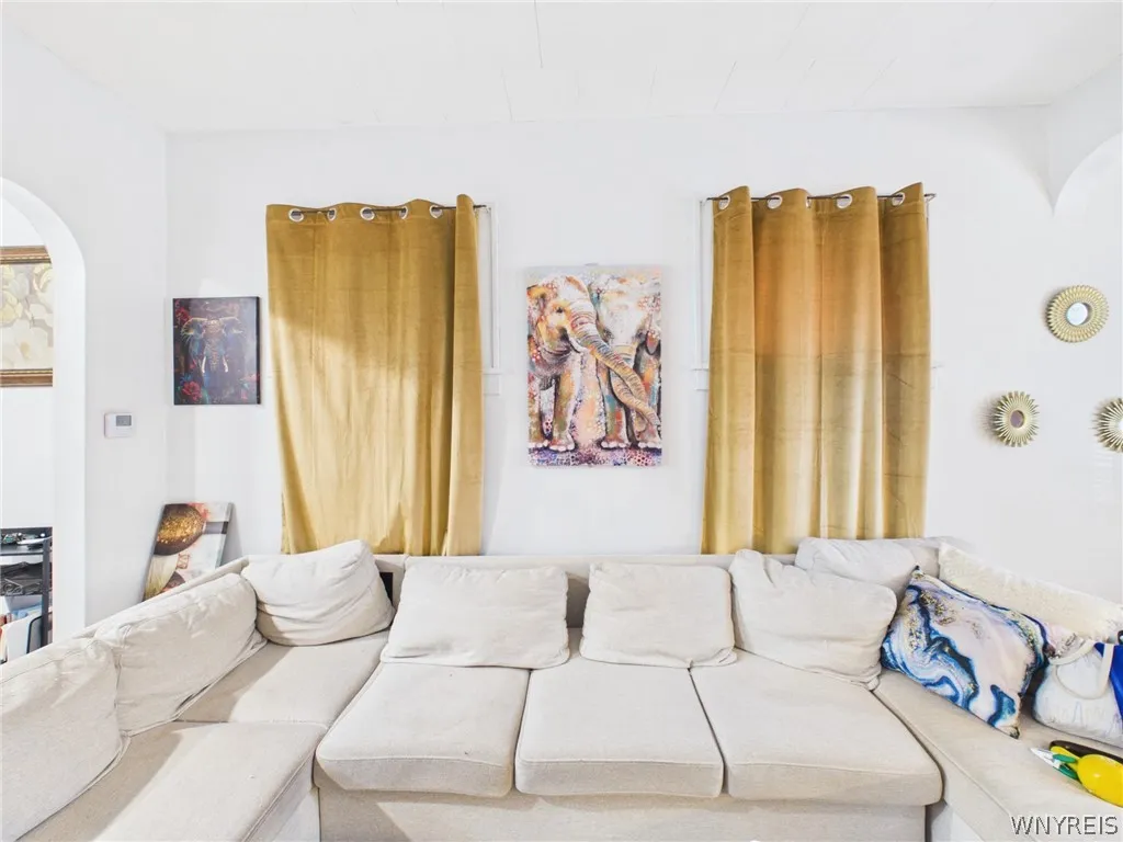 Living room, second angle: The front sitting area, filled with natural light from the bank of windows.
