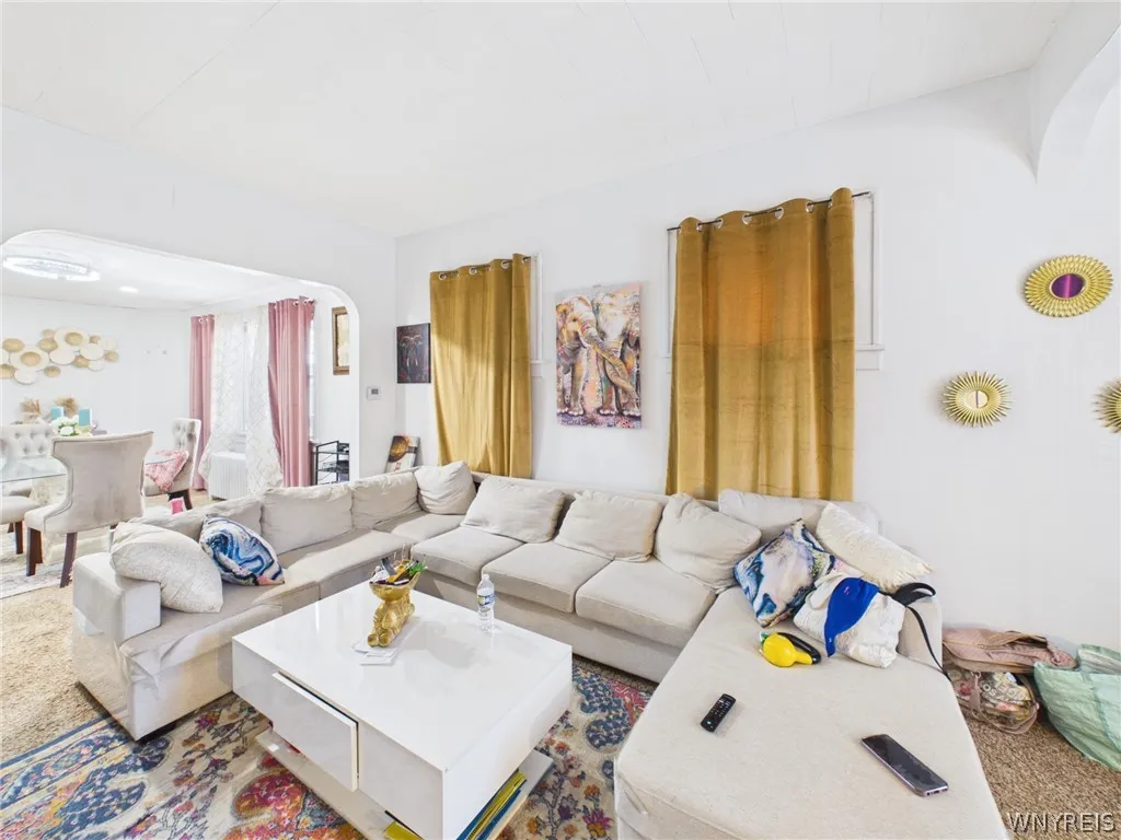 Primary Bedroom: A large bedroom with sloped ceilings, a painted accent wall, abundant natural light, wood-look flooring, a closet and a glass-paned exterior door.