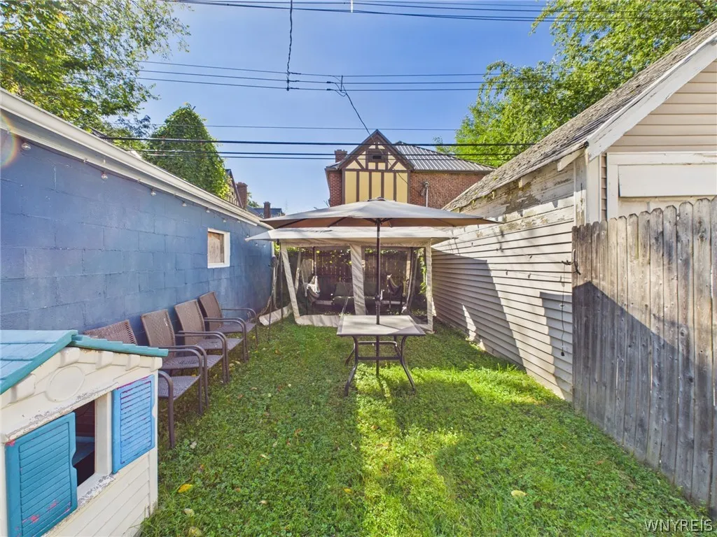Backyard patio area: Space to sit and entertain, with a gazebo, an umbrella table and seating along the garage wall.