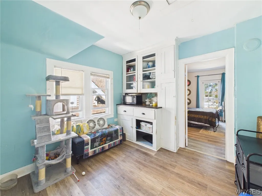 2md Bedroom or Flex Room: This room has hardwood floors, sloped ceilings, a tall window and a classic paneled door.