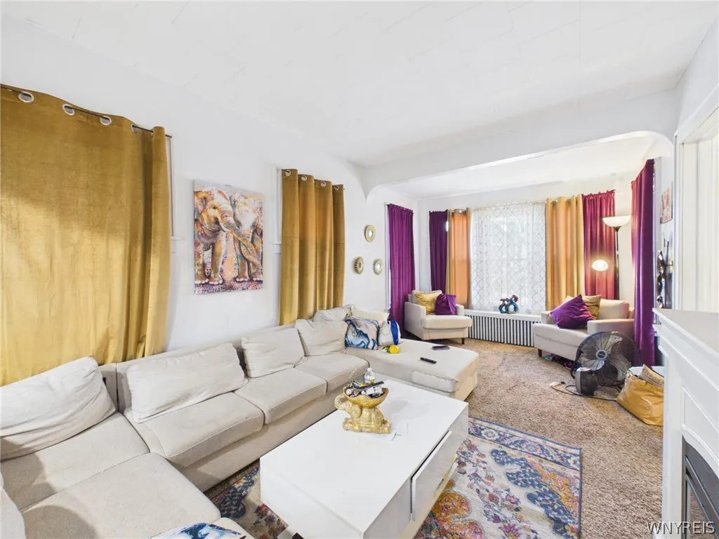 Living room, third angle: The front sitting area, filled with natural light from the bank of windows.