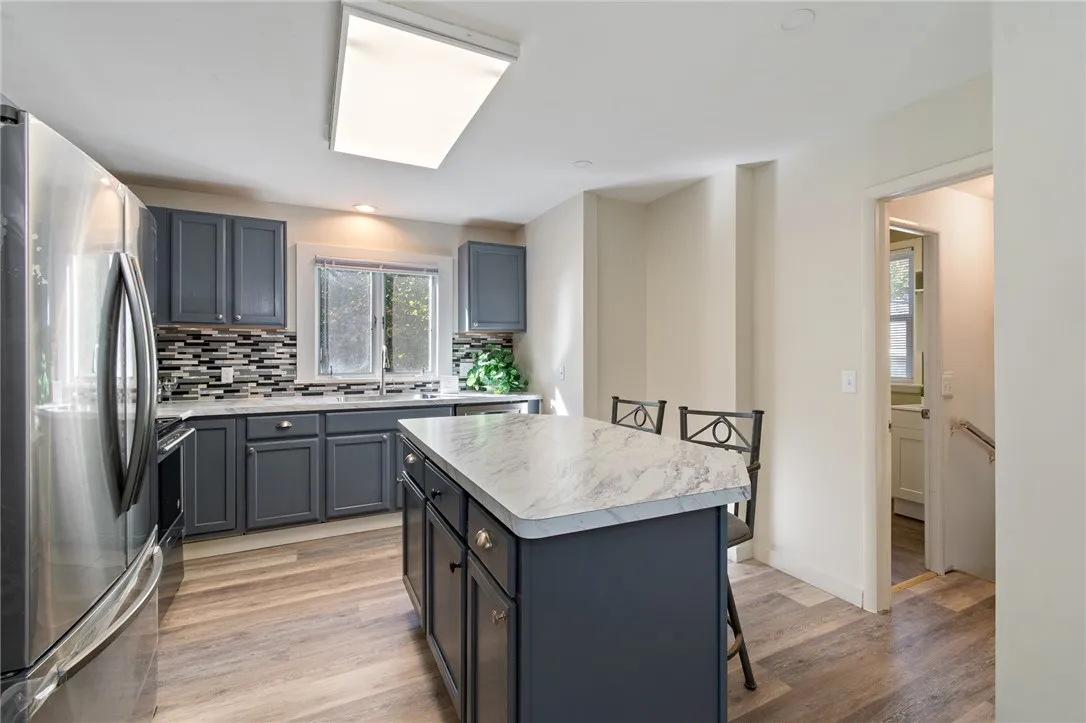 The kitchen - an island, enjoy your morning coffee here! There’s even an adjacent FULL BATH!