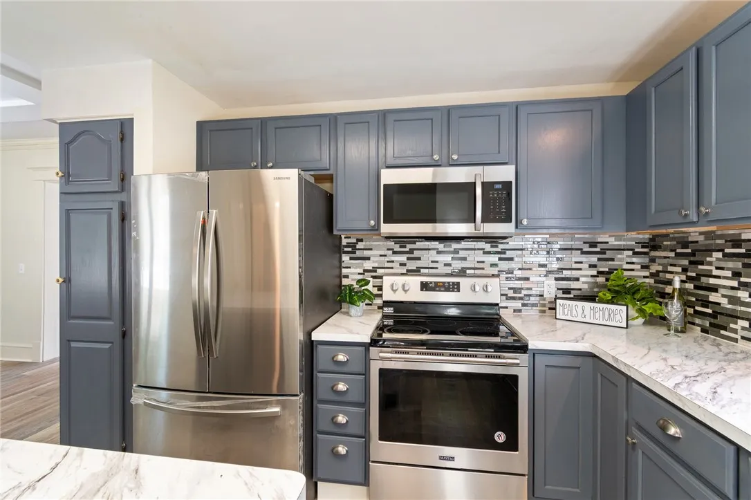 The tile backsplash- updated counter and newer flooring gives this kitchen a fresh, new look! All appliances stay!