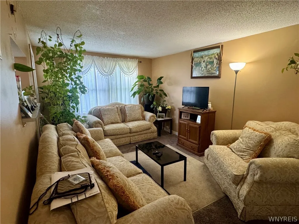 Plentiful natural light streams through large windows into this welcoming living area.