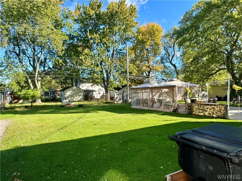 Mature trees frame a wide, grassy lawn perfect for outdoor activities and relaxation.