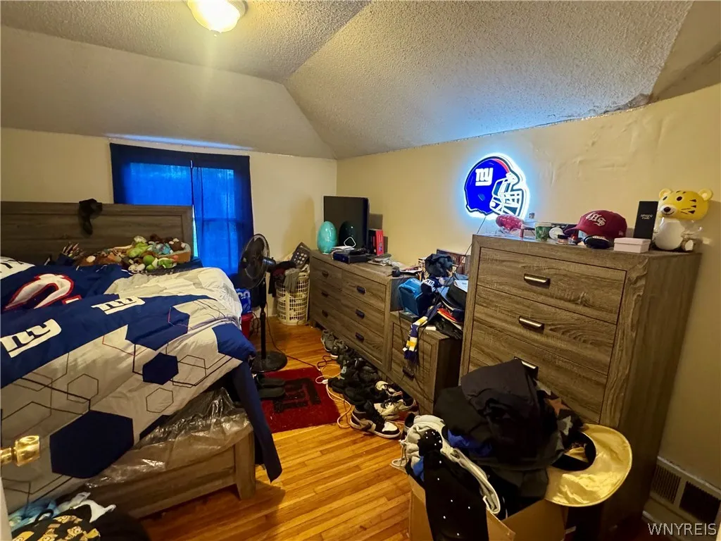Warm hardwood floors and angled ceilings characterize this upper-level bedroom space.