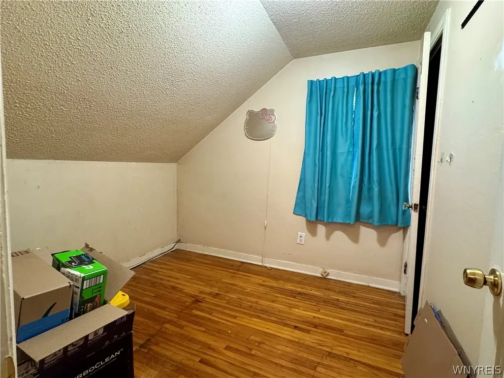 Sloped ceilings and hardwood flooring define this cozy upper-level bedroom.