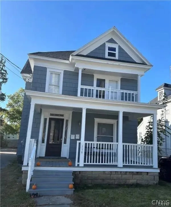 A classic two-story exterior showcases a spacious covered front porch and upper-level balcony.