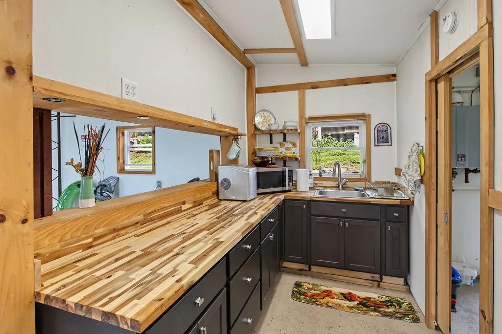 Rich wood countertops and exposed beams define this functional kitchen workspace.