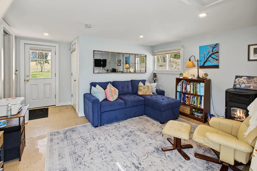 Recessed lighting illuminates this cozy living space complete with a freestanding fireplace.