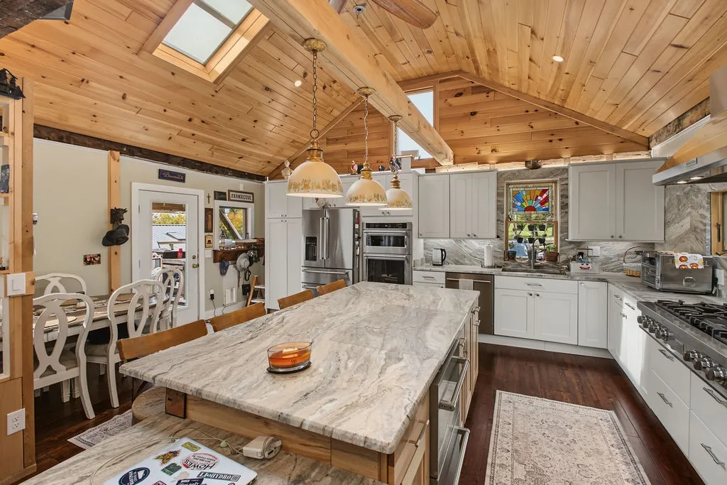 Gleaming stone countertops and a vaulted pine ceiling anchor this beautifully designed culinary space.