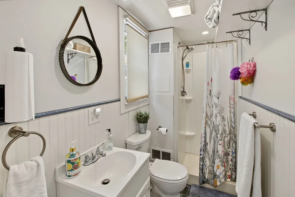 Beadboard wainscoting and a neat shower stall define this efficient, functional bathroom.