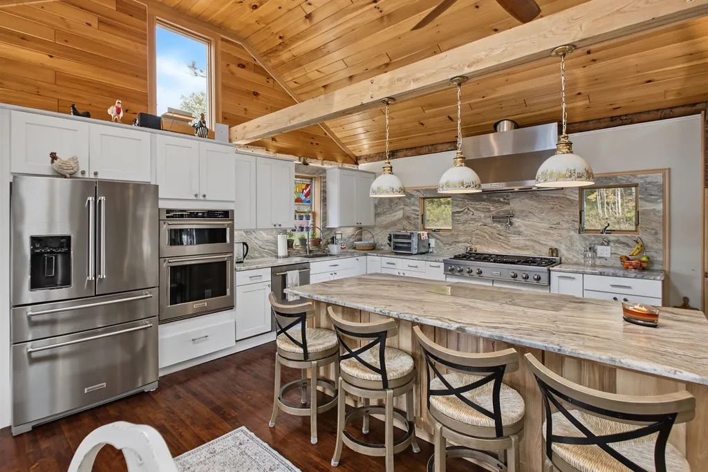 Warm wood ceilings and thick stone countertops define this custom culinary space.