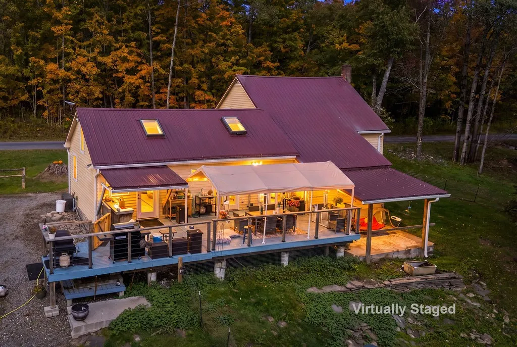 An elevated wood deck with covered dining spaces overlooks the surrounding forest landscape.