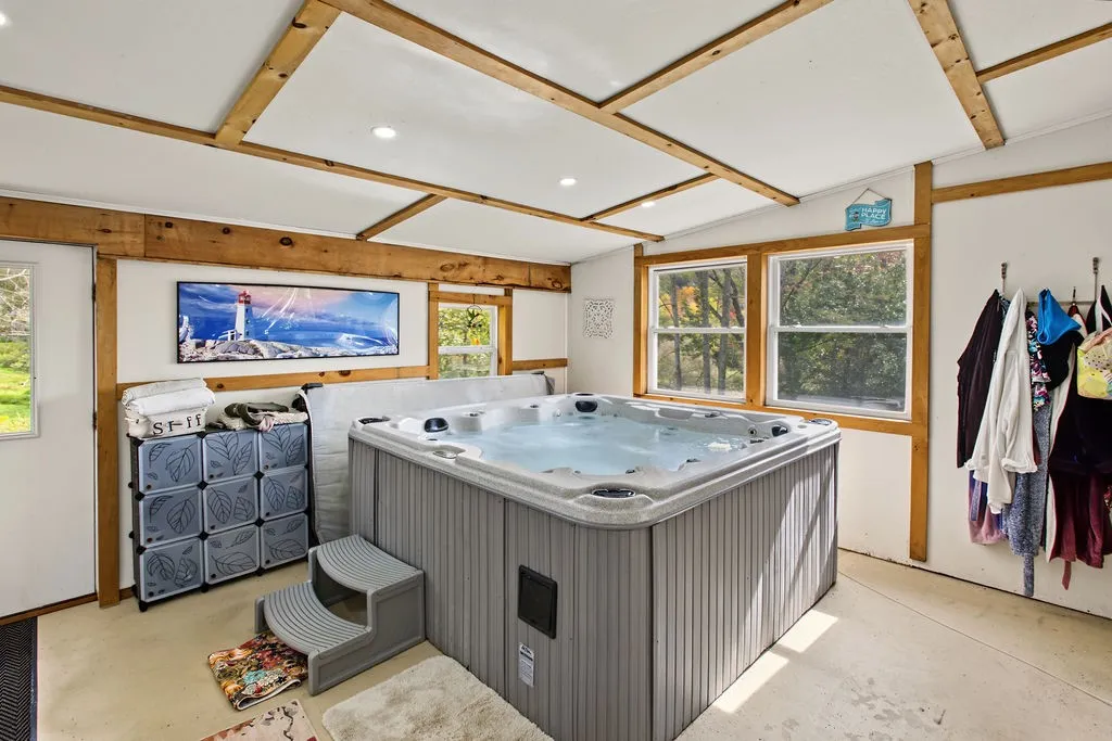 Exposed wood beams and a large hot tub define this versatile indoor spa room.