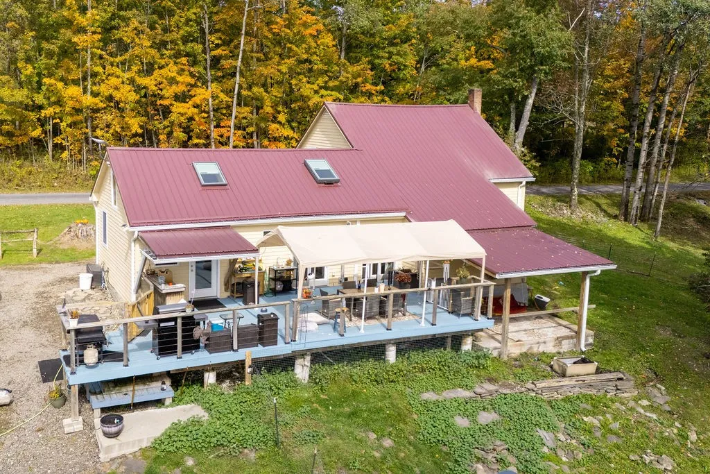 An elevated wood deck with dual awnings looks out over a private grassy yard.