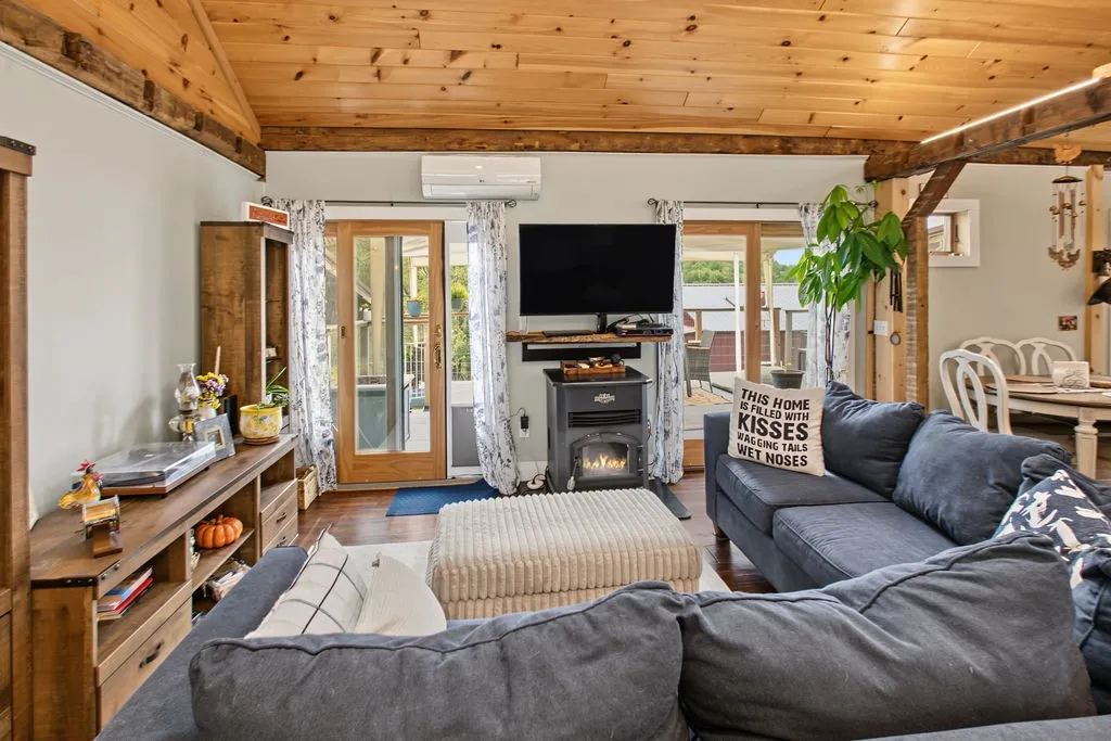 Rich wood plank ceilings and matching beams anchor this inviting open-concept living area.