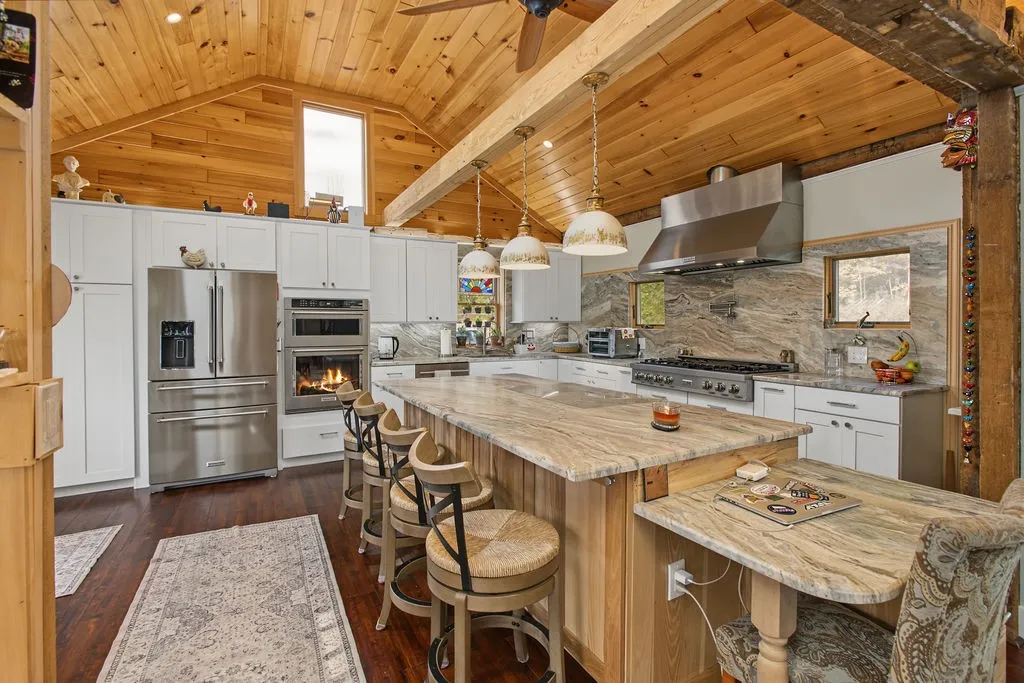 Gleaming stone countertops and a vaulted wood ceiling highlight this beautiful gourmet kitchen.