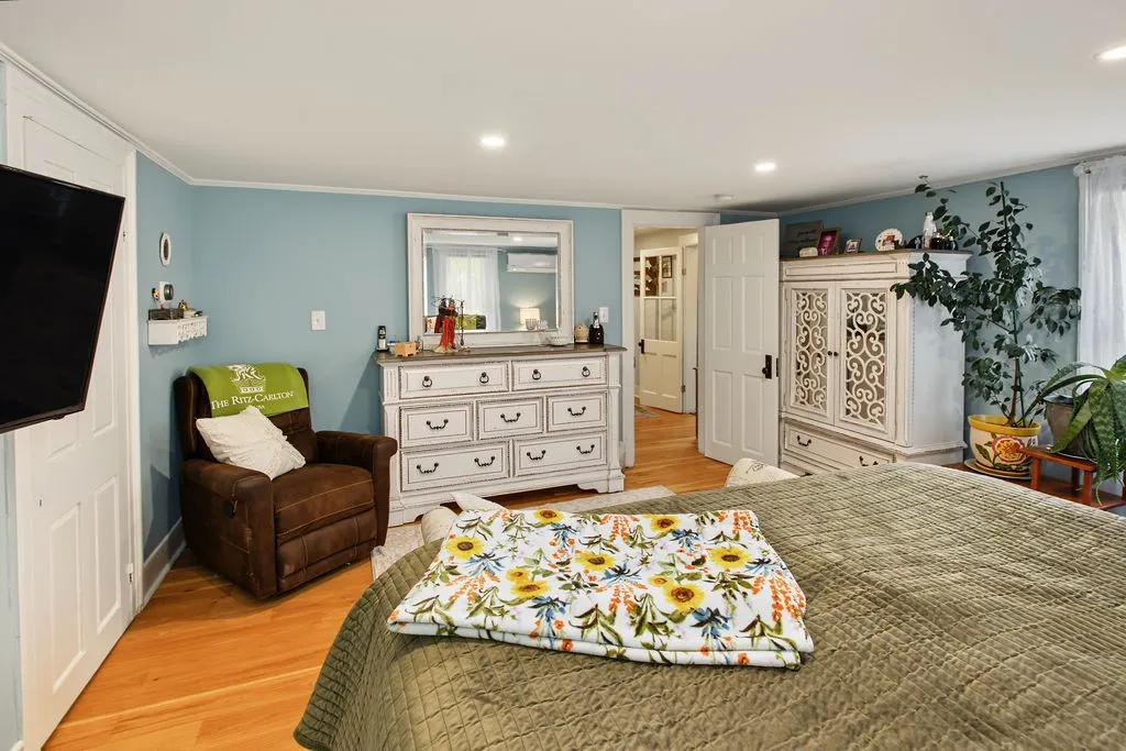 Gleaming hardwood floors and recessed lighting anchor this comfortable primary bedroom suite.