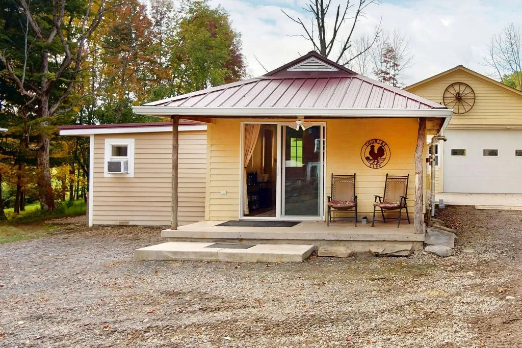 A welcoming front porch with concrete steps leads into this charming country cottage.