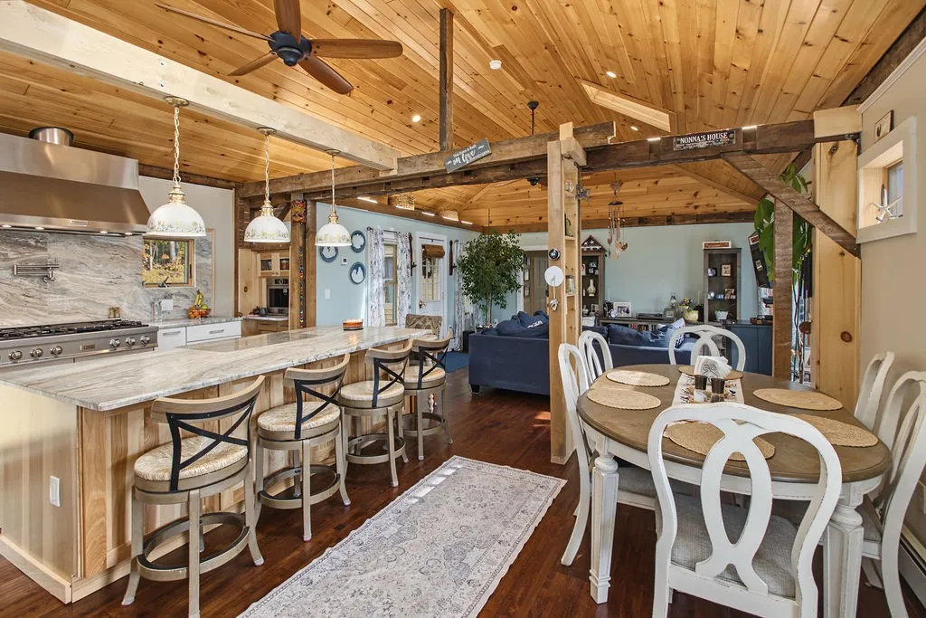 Warm wood ceilings and exposed timber beams define this open dining and kitchen area.