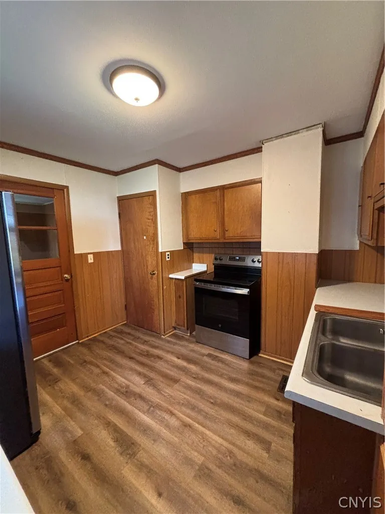 Rich wood cabinetry paired with classic paneling coordinates beautifully with durable vinyl plank flooring.